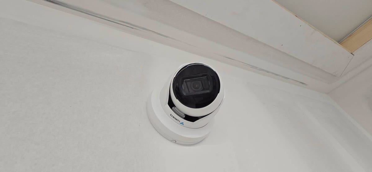 A dome surveillance camera fitted flush to a finished ceiling, wired back over Power over Ethernet.