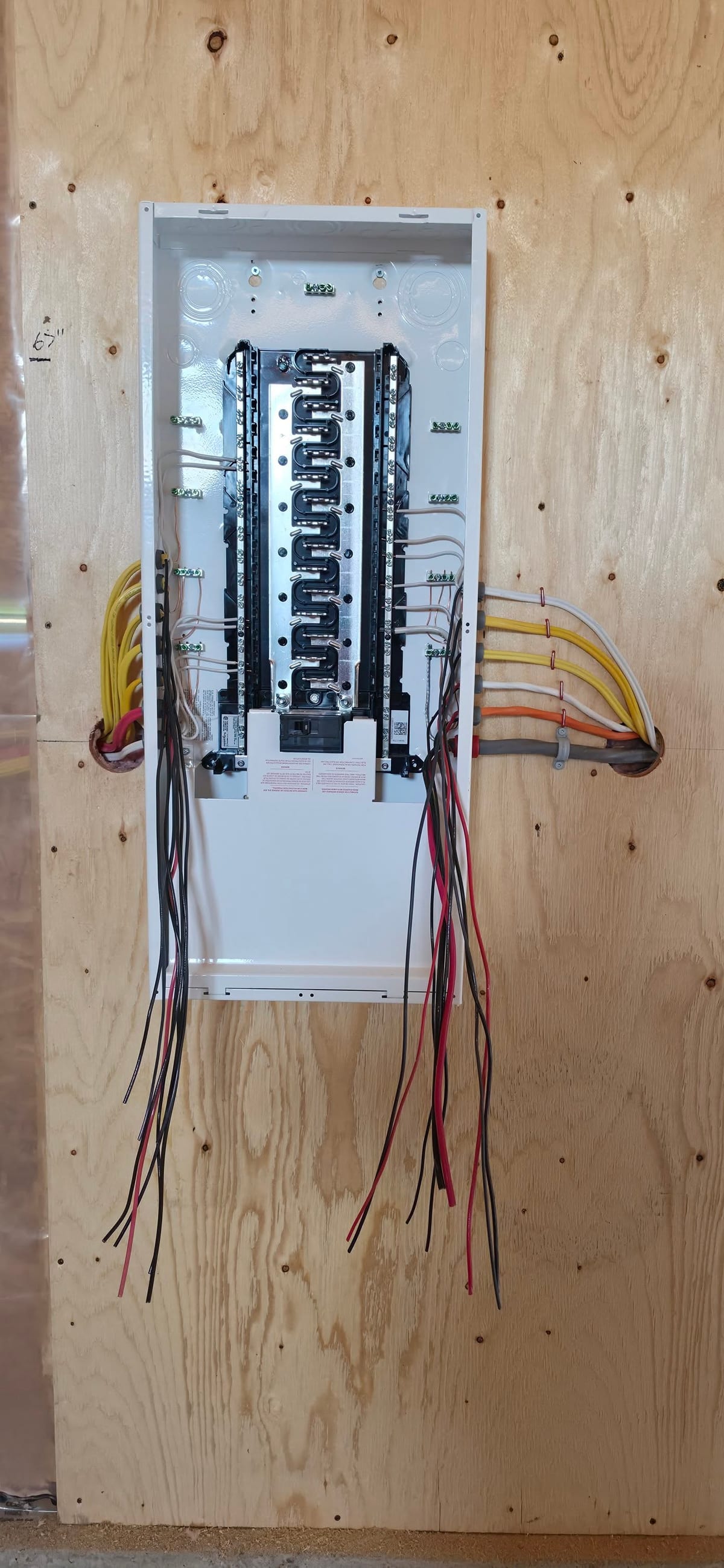 A new load centre mounted on plywood backing with feeders run in and labelled.