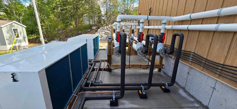 Rooftop mechanical equipment and process piping with the electrical feeds run alongside.