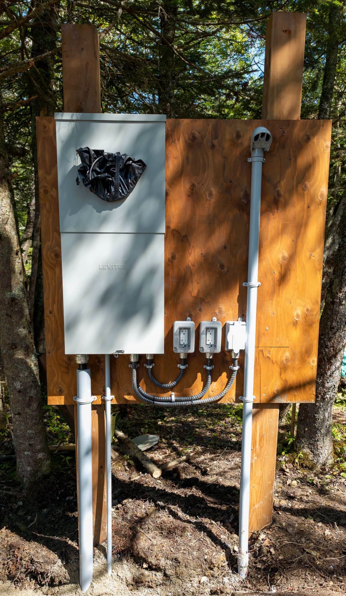 A meter base and panel mounted on a post at a rural lot, fed underground.