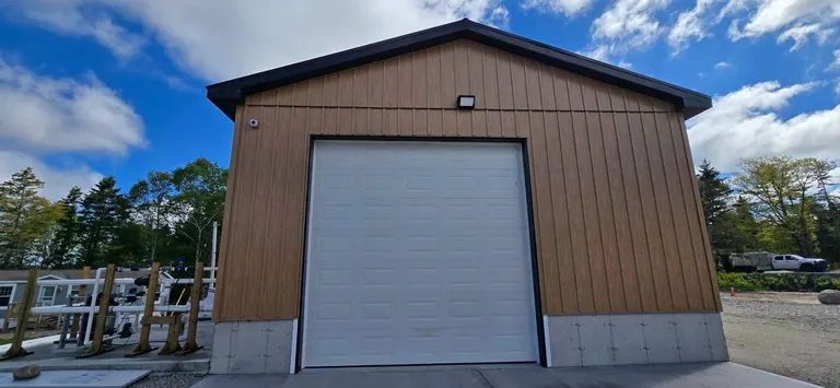 A steel commercial building with an overhead door, serviced by Brents Electrical & Security.